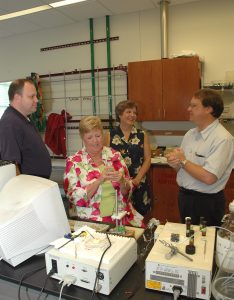 Brenda O'Neal (seated) and Leigh McKenzie (standing, center), both teachers in the Eufaula City School System, are shown working in the lab at UA with chemistry graduate student Roger Campbell (far left) and Dr. Martin Bakker (far right), associate professor of chemistry. 