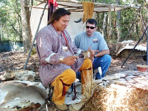 Nöel Grayson, a member of the Western Band of Cherokees (Oklahoma), shows a visitor at Moundville how to knap arrow points.