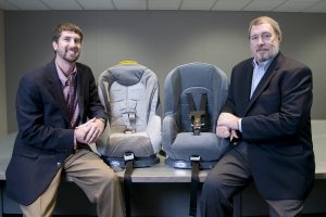 Drs. Richard Swatloski, left, and William Gathings with two new styles of child safety seat latches. (Samantha Hernandez) 
