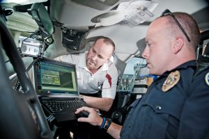 Darrell Arnold, left, a trainer within UA's CAPS center, leans in for a close look at the laptop of John Hall, an officer in the Rainbow City, Ala. police department. (Samantha Hernandez) 