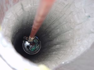 A Digital Optical Mode, one of the project’s approximate 5,000 sensors, is slowly lowered into a hole some 1.5 miles deep in the Earth. (NSF) 