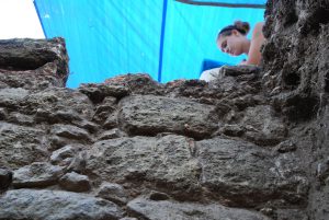 Dr. Becky Mendelsohn, of State University of New York, Albany, works above an excavation unit wall. 