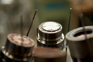 A close-up view shows an iron target fastened to a magnetron cathode. 
