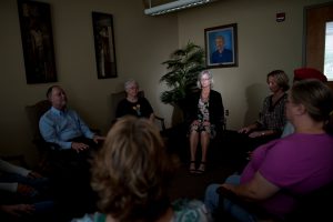 Session participants typically sit in a circle in a darkened room, as depicted in this photo illustration. 
