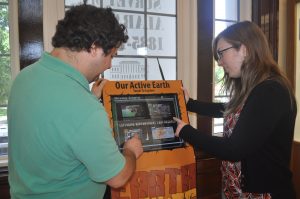 Todd Hester, a naturalist at UA's Museum of Natural History, and Allie Sorlie, an education specialist, take turns using the museum's latest acquisition -- the IRIS Active Earth Monitor Kiosk. 