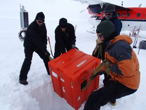 On Nov. 23, 2012, Black Friday, the only shopping Hansen was doing was for a hole ... and it was one she had to dig. Here, researchers lower equipment into place at one of the seismic station sites (Lindsey Kenyon). 