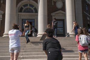 Fashion retailing major Casey Straughn, who is playing 'Carrie Bradshaw,' is photographed walking down the steps of Reese Phifer. 
