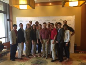 Faculty advisers and some student members of the EcoCAR 3 team at The University of Alabama pose for a photograph at an EcoCAR 3 event with Bill Beggs, center, a team mentor with General Motors. The first-year team was recently recognized as the "Team to Watch" by competition organizers. 