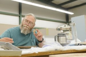 UA's Darrell Smith examines pottery sherds from Lauderdale County. 
