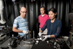 From left, graduate student Mohammad Parvinnezhad Hokmabadi, Dr. Patrick Kung, and Dr. Seongsin Margaret Kim work with the terahertz metamaterial in Shelby Hall. 