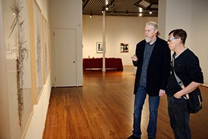 William Dooley and a gallery visitor discuss one of the works in the permanent collection.