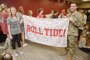UA seniors Miranda Cobb and David Receniello display a UA flag signed by UA students, which will be sent to a military member deployed overseas.