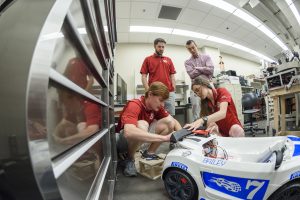 Engineering students including Michael Outlaw and Rebecca Dietz, front, along with Nicholas Rodriguez, standing left, and Christopher Augustine, standing right, worked with other students during the spring semester on the car.