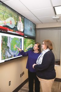 Two women look at tornado map.