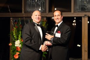 Kenny Ricks receives The University of Alabama's Hackney award from Chuck Karr.