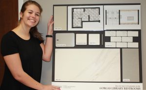 Photo of a woman showing samples of bathroom finishes