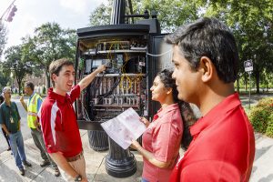 Transportation engineering researchers at The University of Alabama work to enhance the computers inside a traffic lights control board.