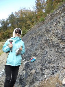 A graduate student in geology collects fossil samples from a shale outcrop in Alabama.