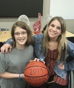 Two female wheelchair basketball players pose for a photo.
