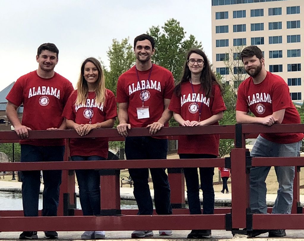 Five UA engineering students stand on a pedestrian bridge in Huntsville at the IEEE SoutheastCon 2019. 