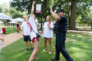 A campus police officer interacts with students on the Quad.