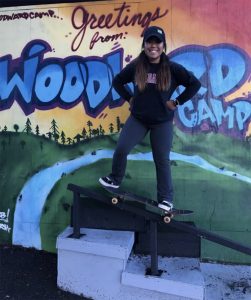 Students stands on skateboard at Woodland camp.