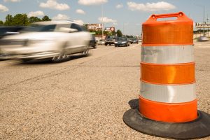 An orange construction barrel on a road