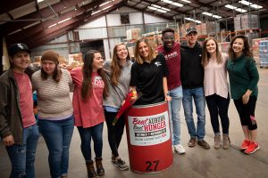 Students stand around a collection barrel at the West Alabama Food Bank. 