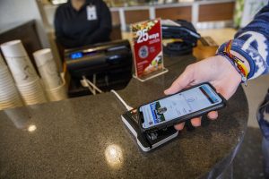 Person using cell phone to demonstrate ACT Card in Apple Wallet