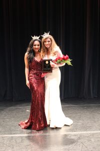 Miss University of Alabama 2020 Isabella Powell (right) poses in a white dress and flowers with Miss University of Alabama 2019 Tiara Pennington whose wearing a red dress