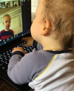 A child at a computer seeing another child through videoconference. Photo courtesy of Andi Gillen.