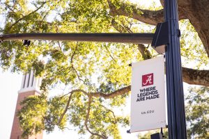 A "Where Legends are Made" banner near Denny Chimes on the UA Quad
