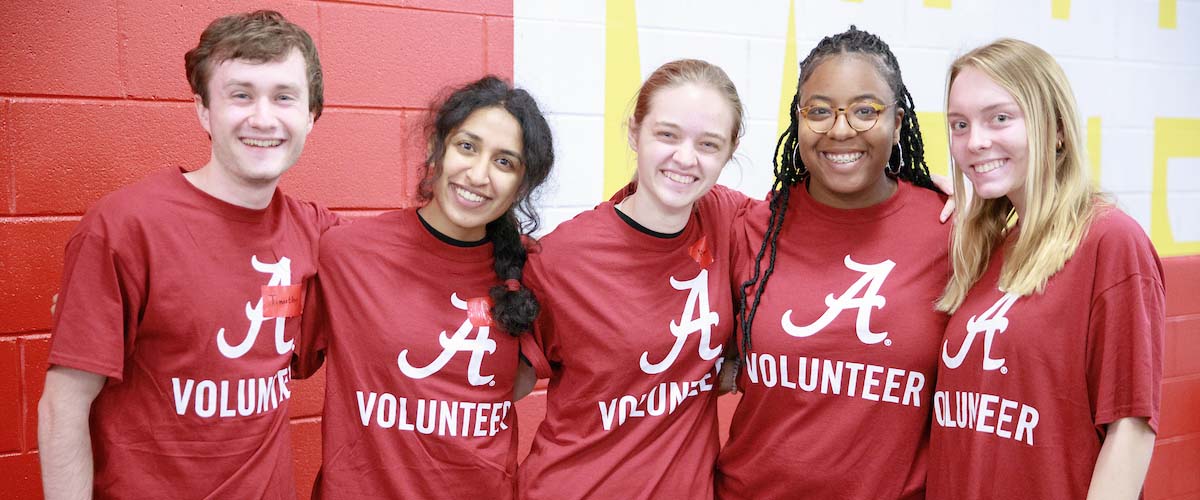 five students posing for photo while volunteering in the community