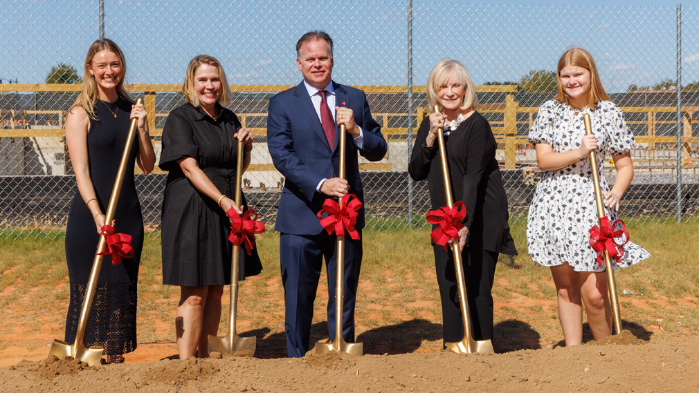 Members of the Smith family hold ceremonial gold shovels at a groundbreaking.